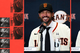 A smiling man wearing a San Francisco Giants baseball cap and jersey sits at a press conference microphone, with baseball-themed images in red and black on the side.